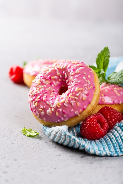 Rosquillas rosas sobre fondo gris