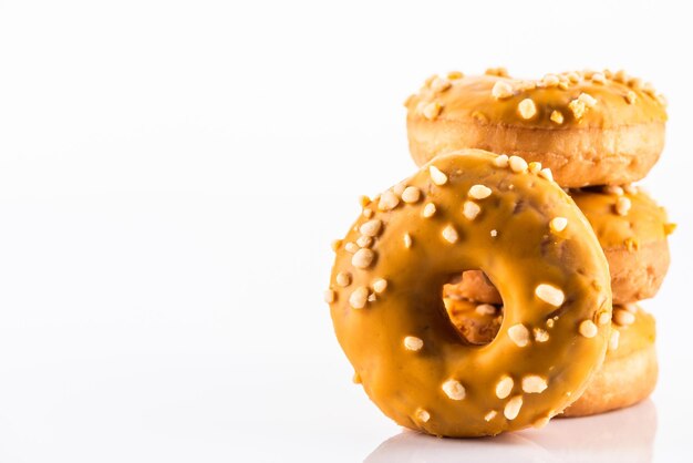 Rosquinha de caramelo salgado ou rosquinhas em fundo branco reflexivo com espaço de cópia