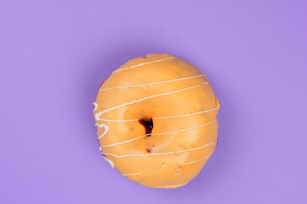 Rosquinha doce vitrificada em um fundo roxo Closeup de uma sobremesa doce Vista de cima