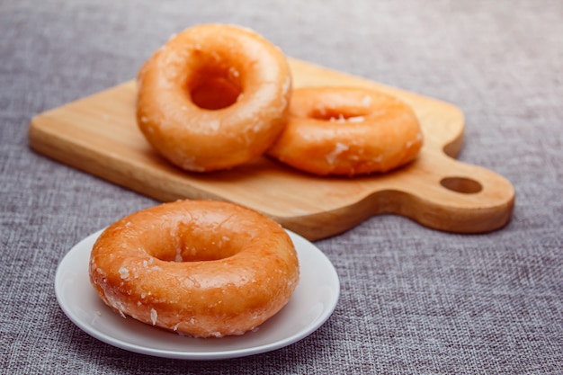 Foto rosquinha toppint com açúcar em uma placa de cor branca.