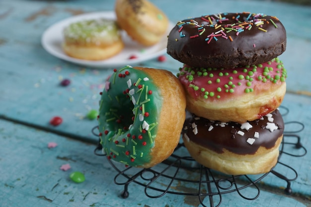 Rosquinhas coloridas caseiras e café preto na mesa de madeira rústica turquesa