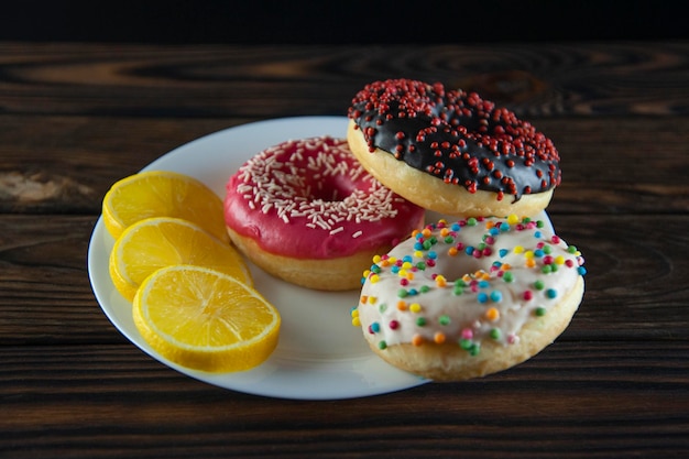 Rosquinhas coloridas em um prato branco com limão