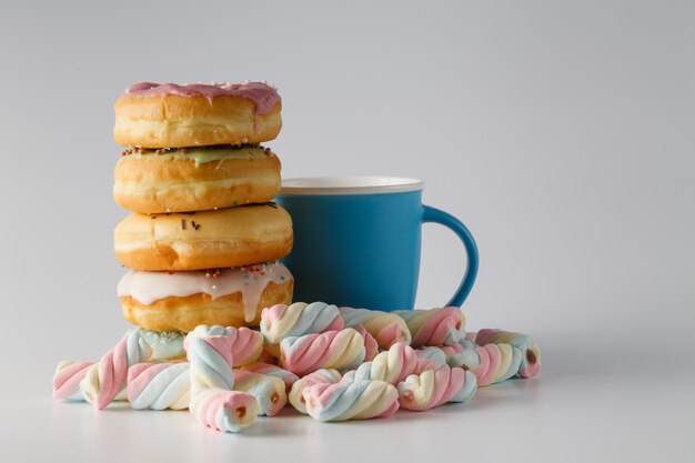 Rosquinhas coloridas no espaço branco liso