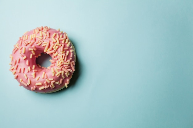 rosquinhas com granulado e esmalte em fundo colorido Rosquinhas planas leigas em um fundo colorido