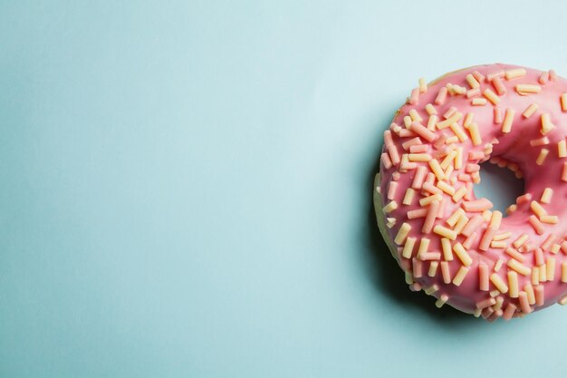 rosquinhas com granulado e esmalte em fundo colorido Rosquinhas planas leigas em um fundo colorido