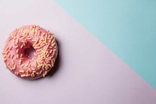 rosquinhas com granulado e esmalte em fundo colorido Rosquinhas planas leigas em um fundo colorido