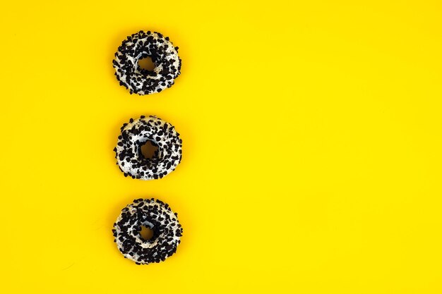 Foto rosquinhas de chocolate em um fundo amarelo estão no espaço de fundo do seu anúncio