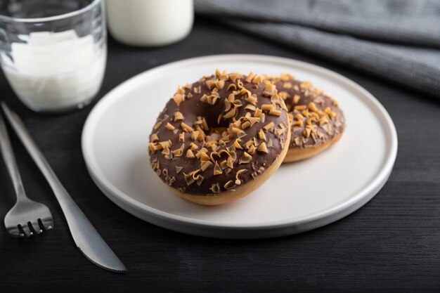 Rosquinhas de chocolate vitrificadas em um prato na mesa de madeira