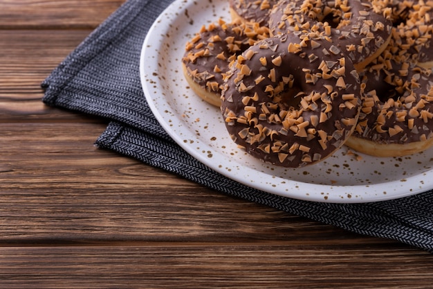 Rosquinhas de chocolate vitrificadas em um prato na mesa de madeira