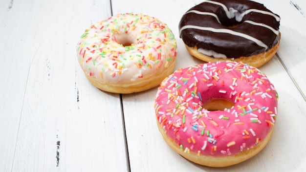 rosquinhas de cores diferentes em uma mesa branca