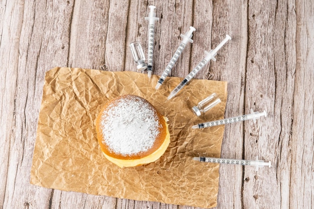 Rosquinhas de creme brasileiras cercadas por várias seringas e ampolas com vista insulintop