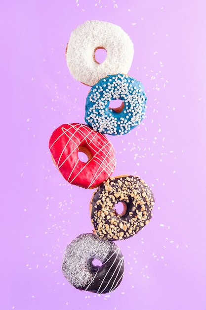 Foto rosquinhas decoradas multicoloridas em movimento caindo