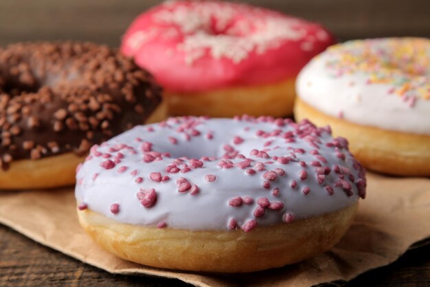 Foto rosquinhas doces sortidas com glacê e molho closeup em uma mesa de madeira marrom