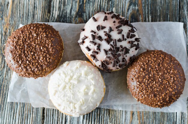 Rosquinhas sortidas com chocolate vitrificado na superfície de madeira