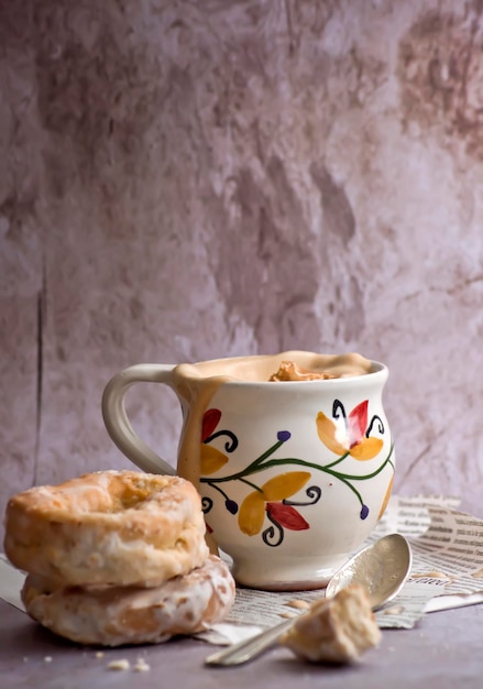Rosquinhas tradicionais ao lado de uma xícara vintage com café com leite