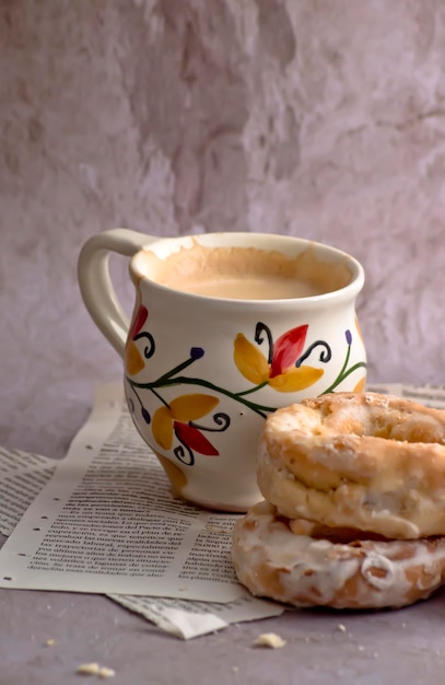 Rosquinhas tradicionais ao lado de uma xícara vintage com café com leite