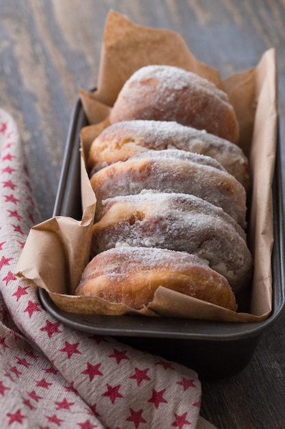 Rosquinhas tradicionais em madeira. Rosquinhas saborosas com açúcar de confeiteiro