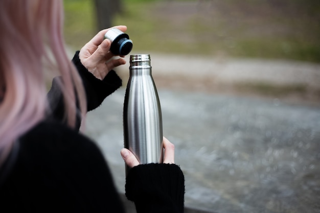 Rostfreie Thermoflasche für Wasser in der Hand.