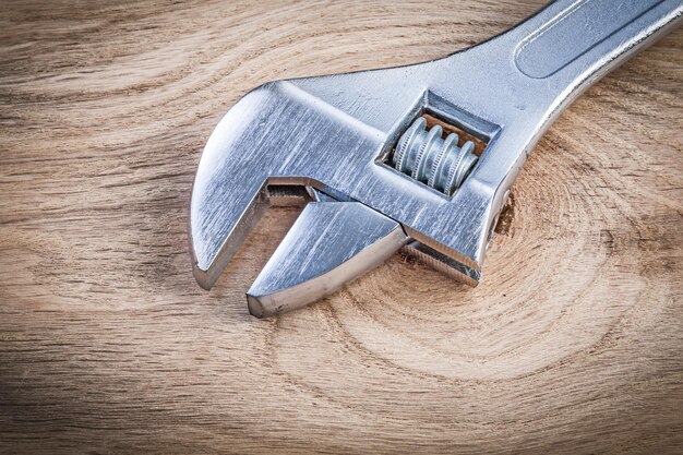 Foto rostfreier verstellbarer schraubenschlüssel auf holzbrett-sanitärkonzept