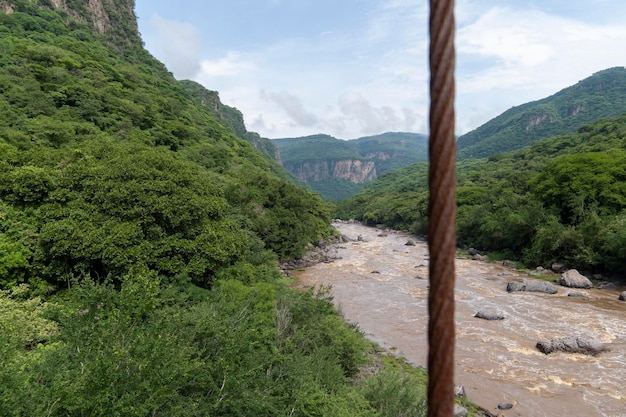 Rostiger Kabelfluss und -berg in der Hintergrundvegetation barranca huentitan guadalajara