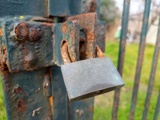 Rostiges altes Vorhängeschloss am Tor des Metallgitterzauns verschlossen Eingang verbotene Sicherheitssicherheit