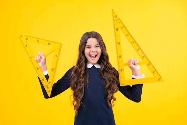 Rosto animado Estudante de uniforme escolar segura medida matemática Medição métrica Equipamento escolar Estudante adolescente estuda disciplinas de haste Expressão espantada alegre e feliz