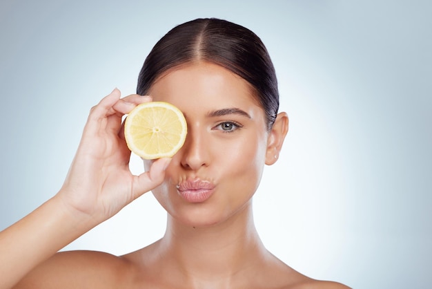 Rosto beijo skincare e mulher com limão no estúdio isolado em um fundo branco Retrato natural e modelo feminino com frutas para nutrição de vitamina c ou dieta saudável, bem-estar ou beicinho de cosméticos