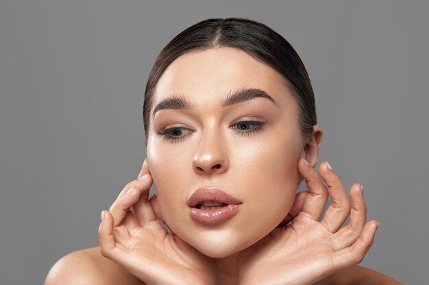 Rosto de beleza mulher jovem e bonita com pele fresca limpa toque o próprio rosto closeup