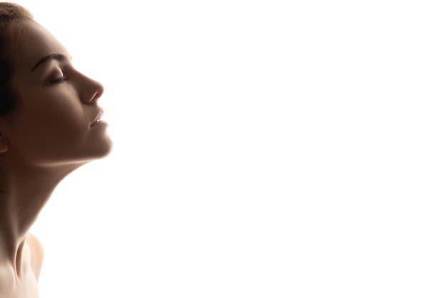 Foto rosto de beleza perfil de silhueta mulher respirando com os olhos fechados isolado no espaço livre em branco mente relaxante garota sonhadora