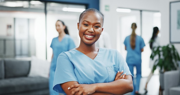 Rosto de enfermeira ou braços cruzados em um hospital movimentado para sobre nós, seguro de vida médico ou suporte de bem-estar Sorria feliz ou mulher negra de saúde em retrato, confiança, confiança ou ajuda no estágio de medicina