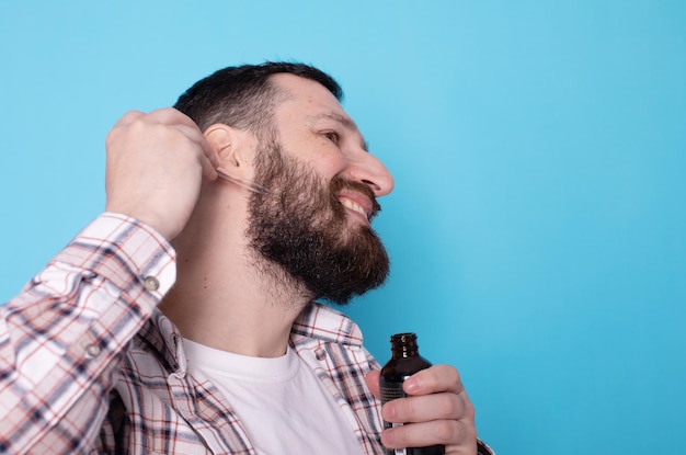 Rosto de homem barbudo e pipeta com óleo para o crescimento da barba