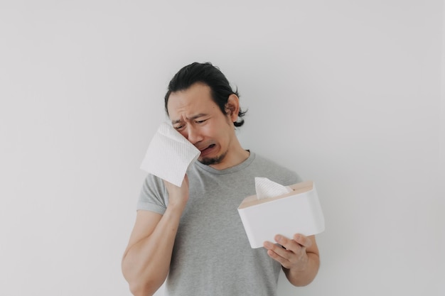 Rosto de homem chorando com a mão segurando um tecido isolado no fundo branco