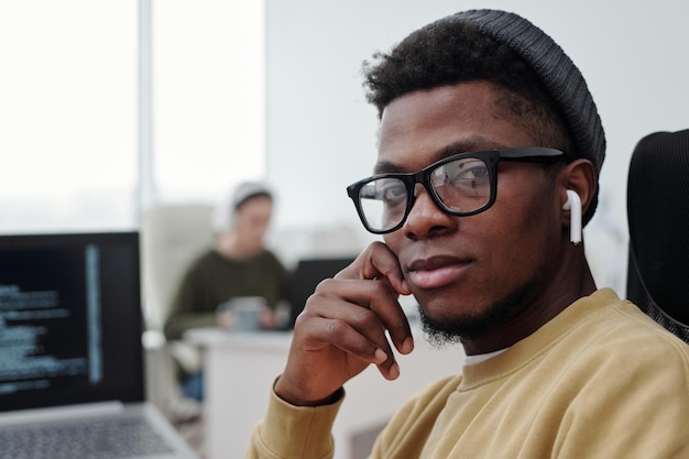 Rosto de jovem programador afro-americano sério olhando para a câmera