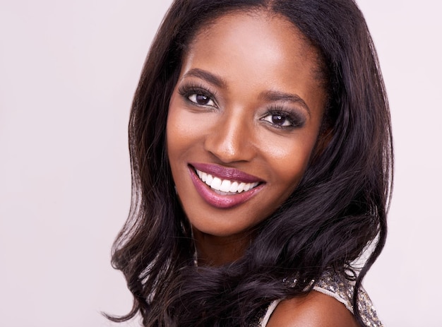 Rosto de maquiagem de mulher negra feliz e no cenário de estúdio Tratamento facial de beleza cuidados com a pele ou dermatologia e cosméticos para autocuidado com modelo feminino com brilho ou brilho no fundo