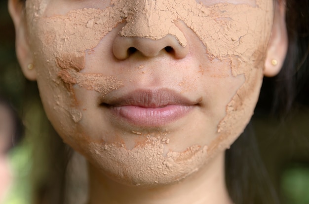 Rosto de menina, aplicação de máscara facial spa de argila para tratamento de beleza