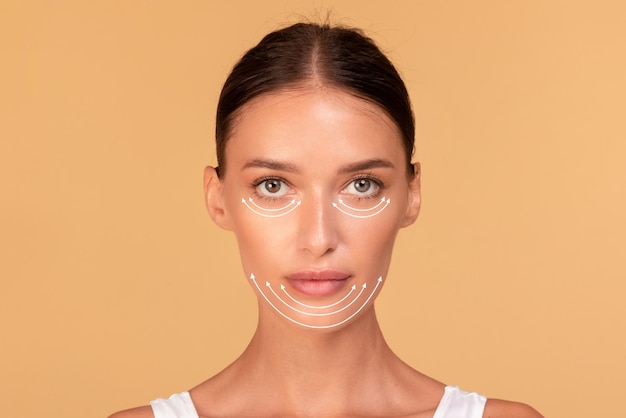 Rosto de mulher de cirurgia plástica Jovem com linhas de perfuração no rosto antes da operação de cirurgia plástica