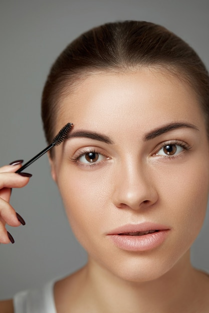 Foto rosto de mulher fechar os lábios de olhos de macro de beleza. tom de pele. correção de sobrancelha