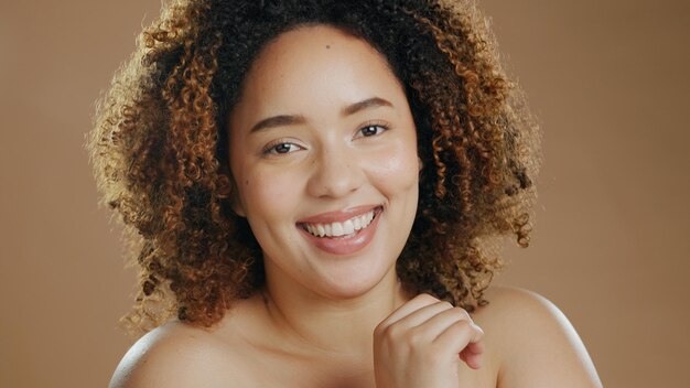 Foto rosto de mulher feliz, dermatologia de beleza natural e bem-estar cosmético em estúdio com sorriso retrato de brilho de pele ou modelo feminino biracial confiante com resultados de cuidados com a pele ou orgulho em fundo marrom