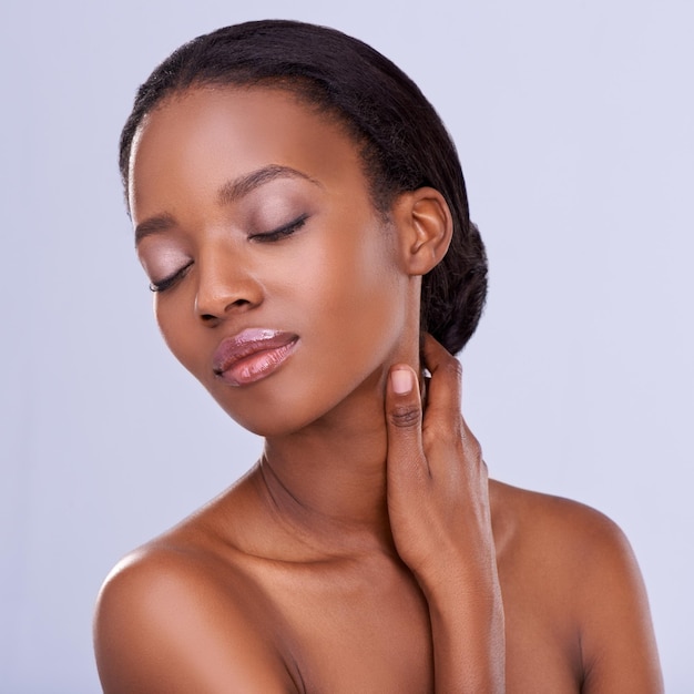 Rosto de mulher negra relaxar ou beleza com maquiagem cosméticos ou pele saudável em estúdio isolado Dermatologia bem-estar ou modelo de menina africana com brilho de lábios ou resultados de cuidados com a pele em fundo roxo