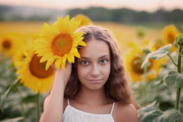 Rosto de retrato de menina adolescente no campo de girassóis.