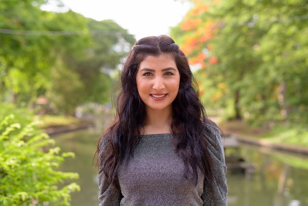 Foto rosto de uma linda jovem indiana feliz sorrindo para o parque ao ar livre