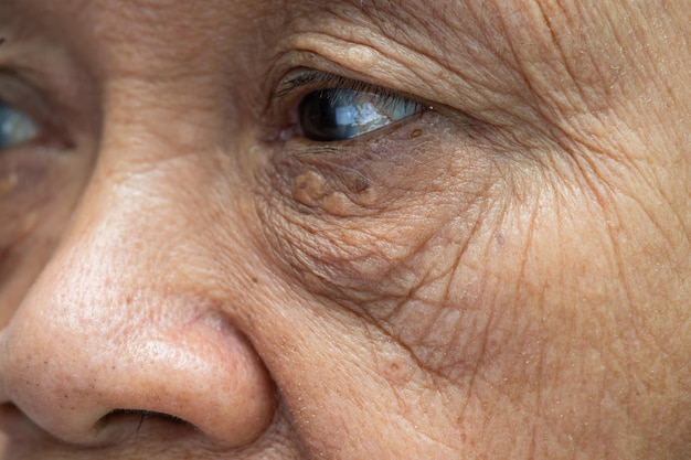 Rosto e olho de uma mulher idosa asiática com rugas, vista aproximada do retrato