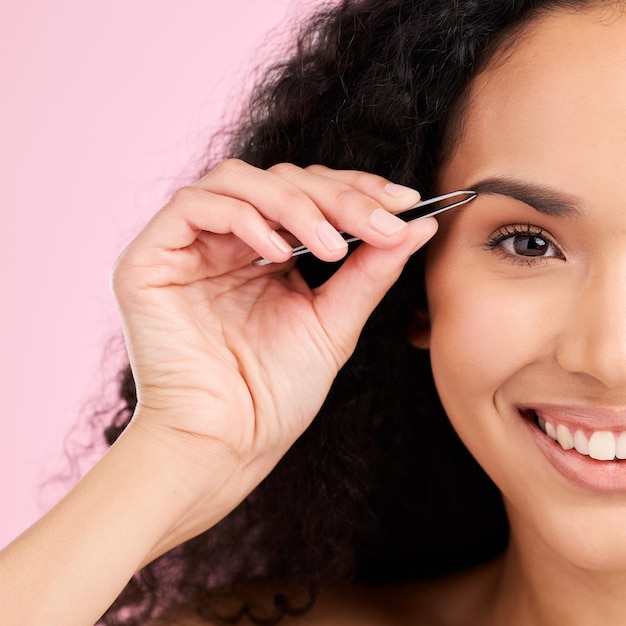 Foto rosto feliz e mulher com pinça para sobrancelha beleza e cuidados isolados em um fundo rosa em estúdio retrato natural de arranque facial e depilação de modelo para bem-estar e estética