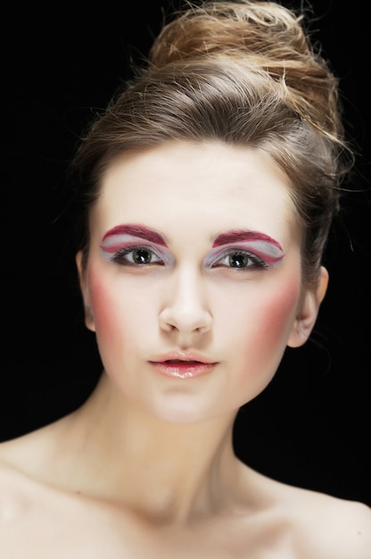 Rosto feminino jovem com maquiagem multicolorida de moda brilhante