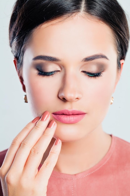 Rosto feminino perfeito closeup Jovem com maquiagem e mão bem cuidada Lábios e unhas cor de rosa