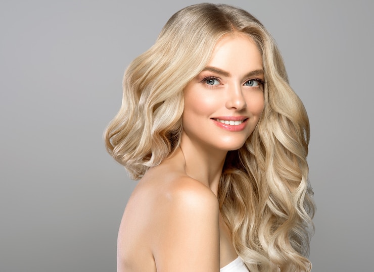 Rosto louro mulher cabelo encaracolado beleza rosto maquiagem natural. Tiro do estúdio.