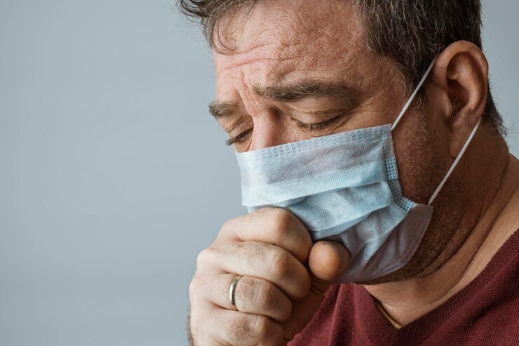 Foto rosto masculino com máscara médica tossindo