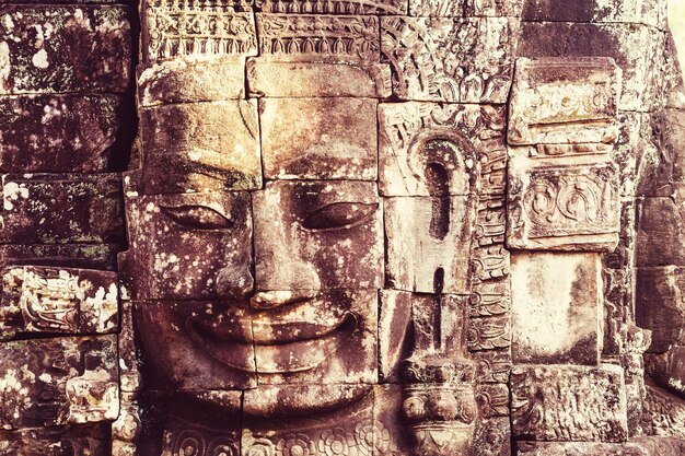 Rostos de pedra do antigo templo da cultura Khmer de Bayon na área de Angkor perto de Siem Reap, Camboja