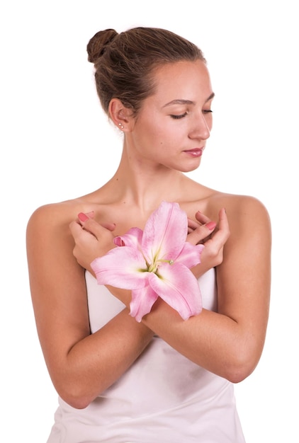 Foto rostro de belleza de la joven mujer hermosa con flor mujer tocando la piel