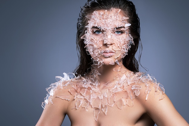 Foto rostro femenino cubierto con muchos pedazos pequeños de vidrio